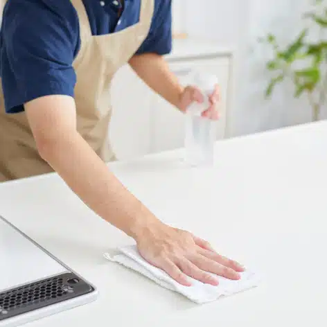 Une personne fait le ménage, elle nettoie un plan de travail.