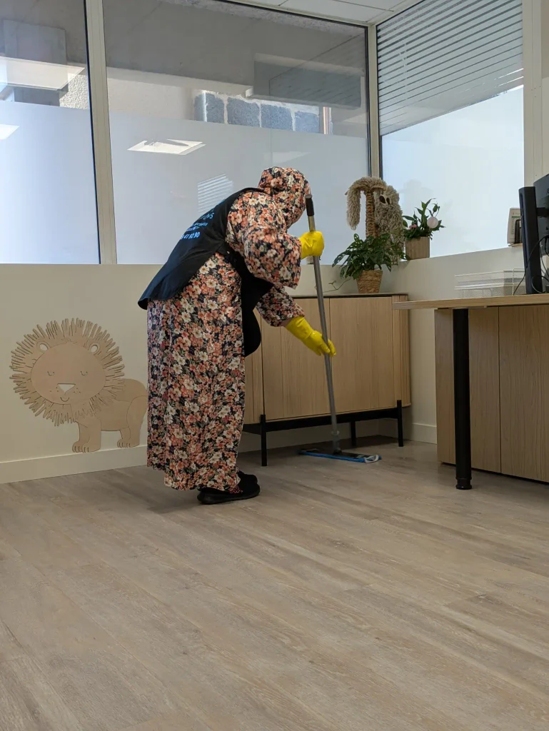 Une salariée M3P Solution balaie le sol d'un cabinet médical.