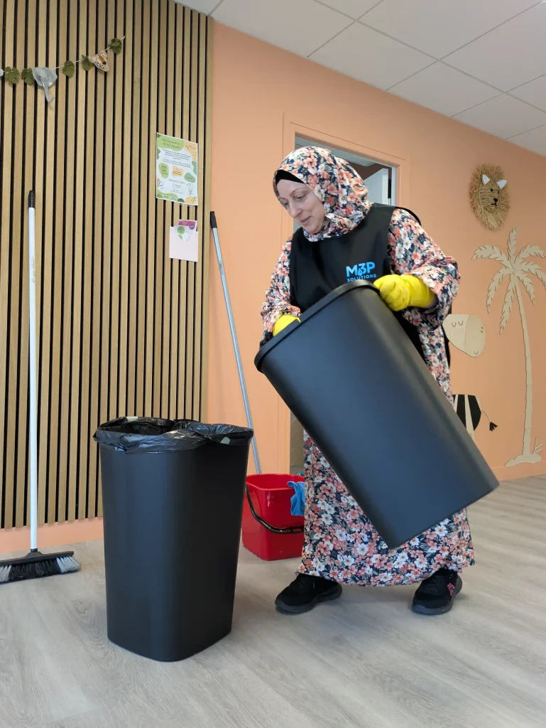 Une salariée M3P Solution vide les poubelles d'une cabinet médical.